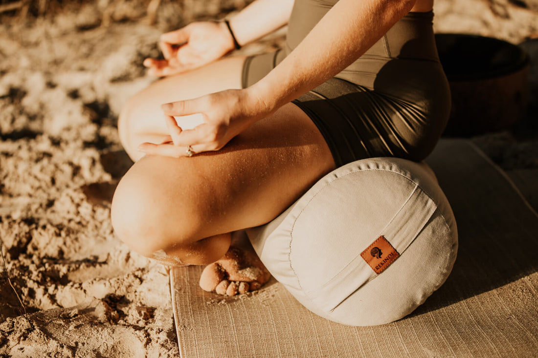 A yogi practicing a morning flow on a jute yoga mat and another doing evening restorative yoga with a bolster.
