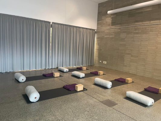 Rectangular yoga bolster in eco-friendly material, ideal for restorative poses and alignment support in Australian yoga studios.
